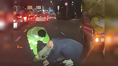 Hong Seok-cheon helps sanitation worker cleaning up trash on a road near Gongdeok Station